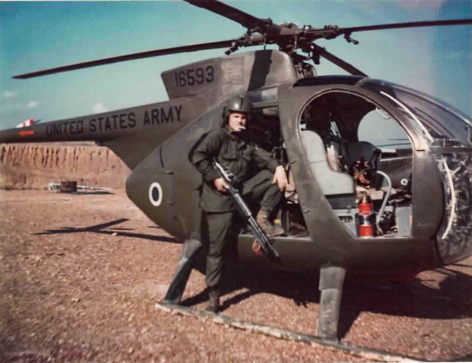 Deloy Evans beside a U.S. Army helicopter during his military service